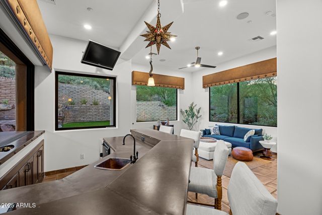 a living room with furniture tv and large windows