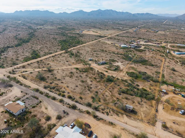 a view of a dry yard with mountains in the background
