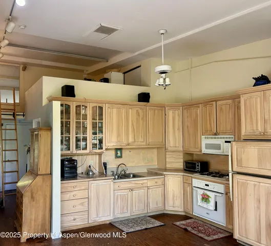 a kitchen with granite countertop a stove a sink and dishwasher wooden cabinets with granite countertops