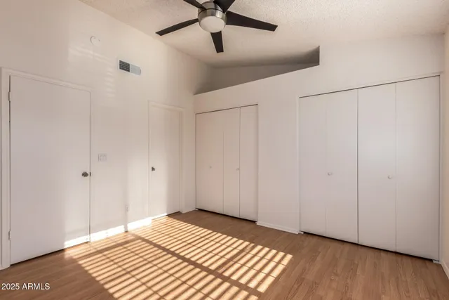 a view of a bedroom with wooden floor a ceiling fan and a ceiling fan