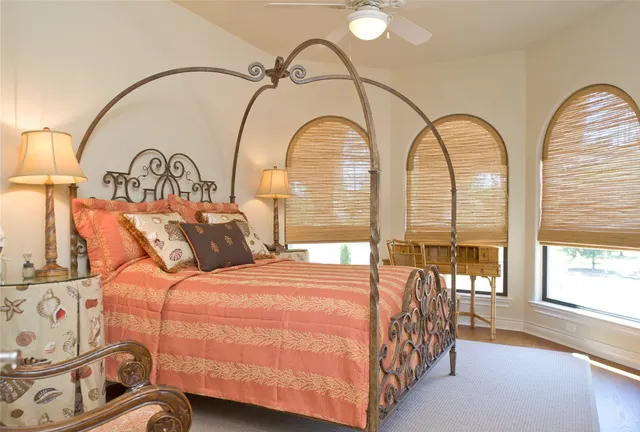 a bed sitting in a bedroom next to a window and a chandelier