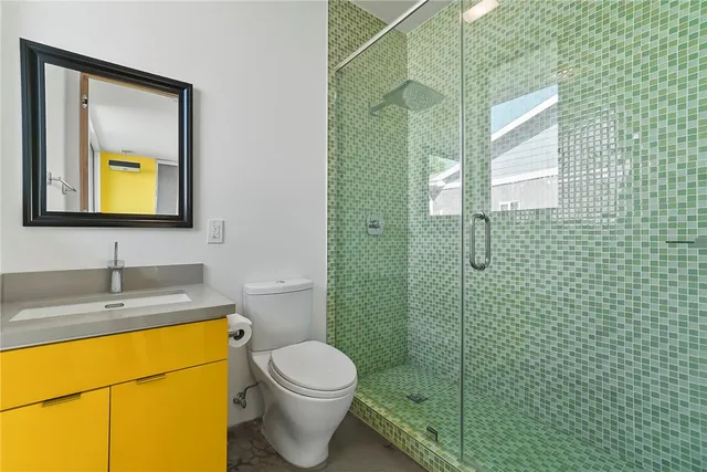 a bathroom with a granite countertop sink toilet and mirror
