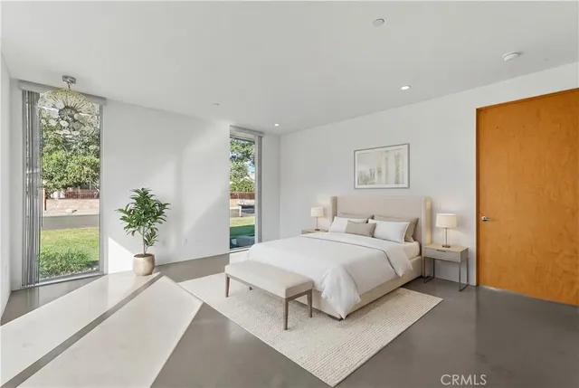 a bedroom with a large bed and a potted plant