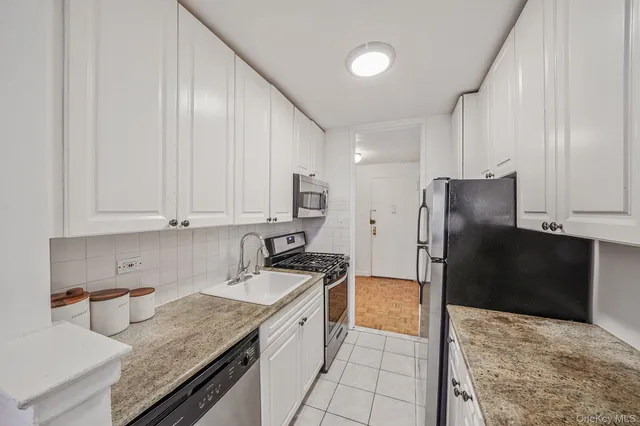 a kitchen with a sink a refrigerator and cabinets