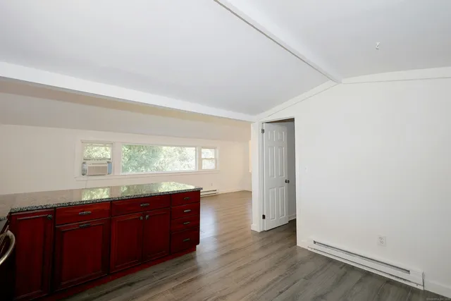 a room with granite countertop wooden floors and a sink