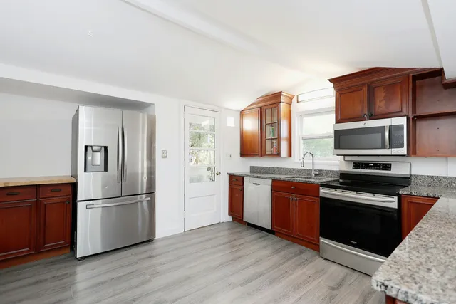 a kitchen with stainless steel appliances granite countertop a refrigerator stove and sink
