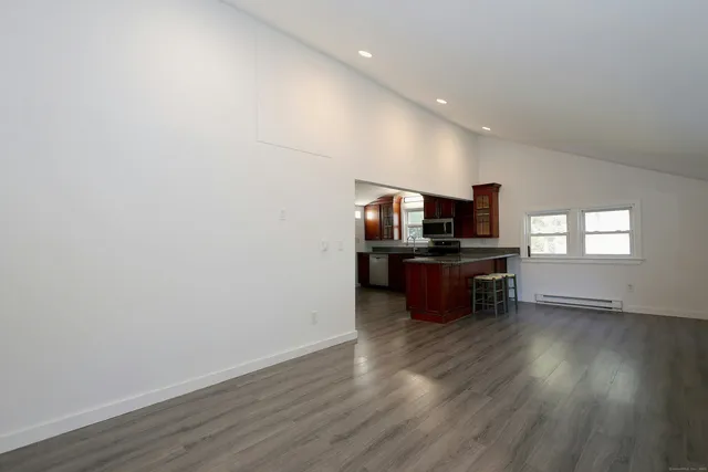 a living room with hard wood floors and a flat screen tv
