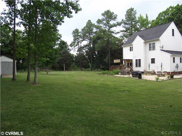 15275 Teman Mill Road Beaverdam, VA 23015 - Photo 2 of 12 a view of a white house with a big yard and large trees