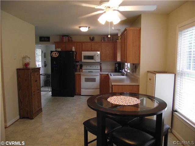 15275 Teman Mill Road Beaverdam, VA 23015 - Photo 5 of 12 a kitchen with stainless steel appliances kitchen island granite countertop a table chairs and a refrigerator