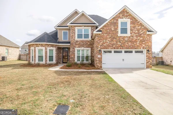 a front view of a house with a yard and garage