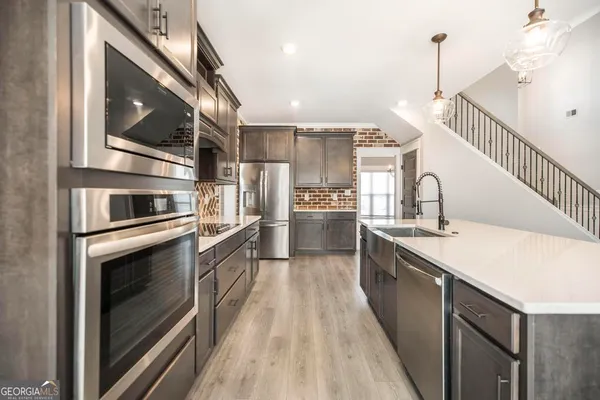 a kitchen with stainless steel appliances a stove a sink and a refrigerator