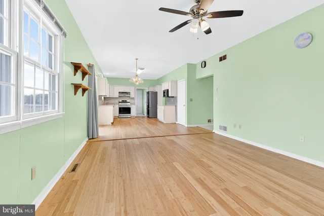 a view of a living room with a ceiling fan and wooden floor