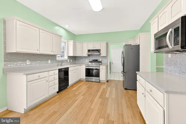 a kitchen with stainless steel appliances granite countertop a refrigerator a stove top oven a sink and dishwasher