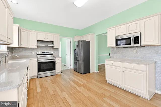 a kitchen with stainless steel appliances a stove microwave and cabinets