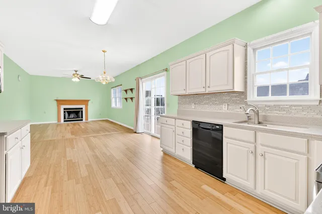 a kitchen with granite countertop a stove a sink dishwasher and a wooden cabinets