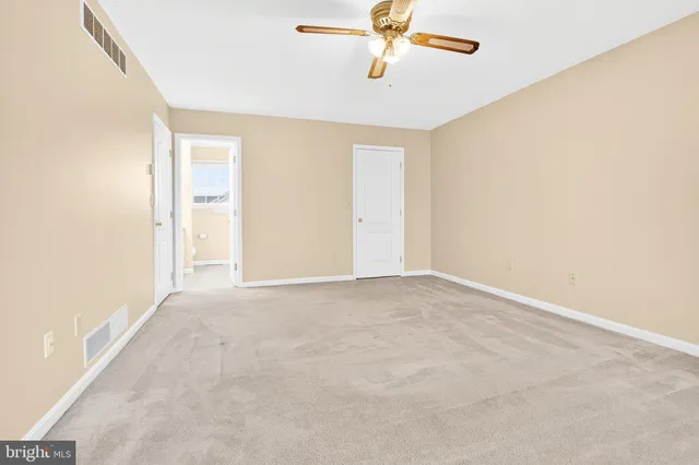 en empty room with a ceiling fan and window