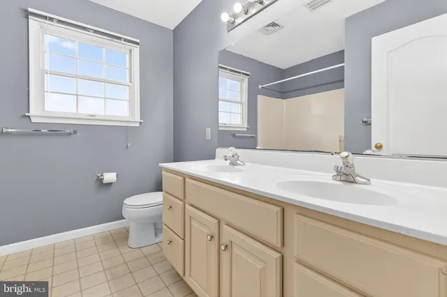 a bathroom with a toilet sink vanity and mirror