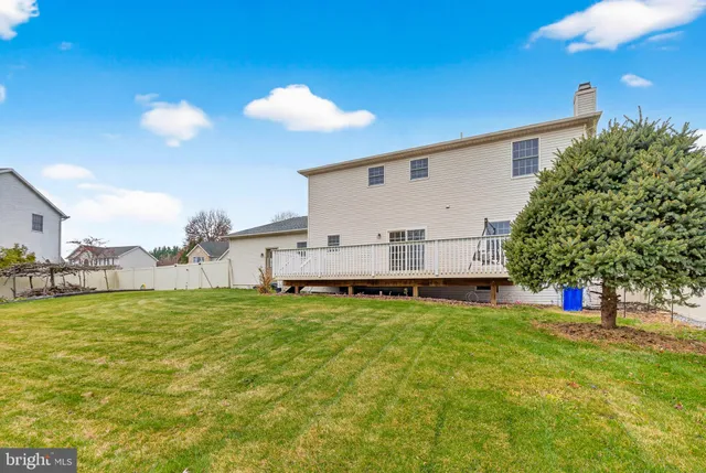 a view of a house with a yard and a large tree