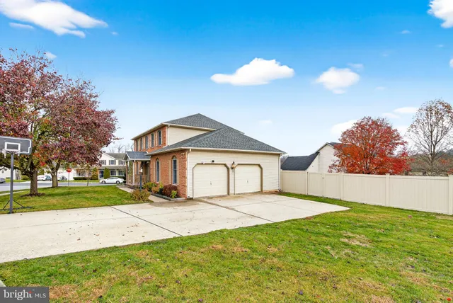 a view of white house with a big yard and large trees