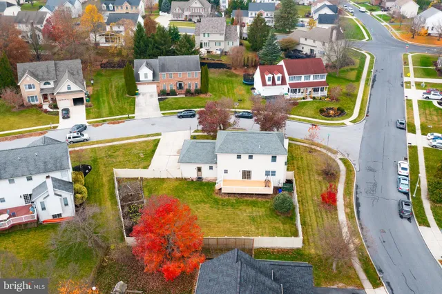 an aerial view of residential houses with outdoor space and parking