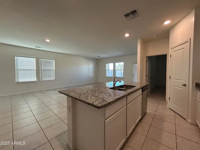 a kitchen with stainless steel appliances granite countertop a sink and a refrigerator