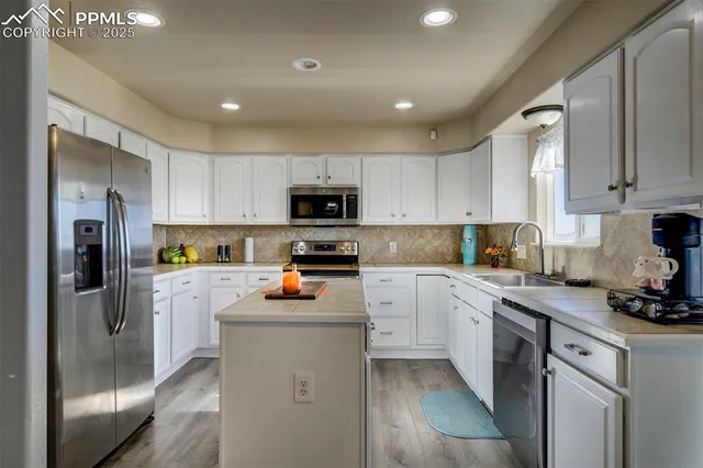 a kitchen with refrigerator a sink and cabinets