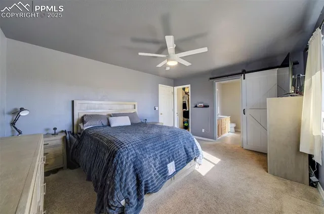 a bedroom with a bed and a refrigerator
