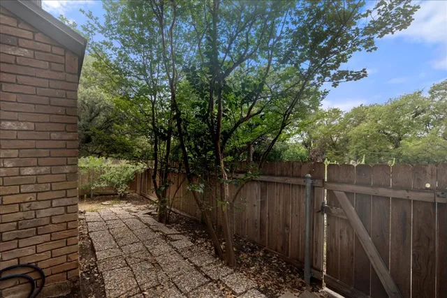 a pathway of a house with wooden fence