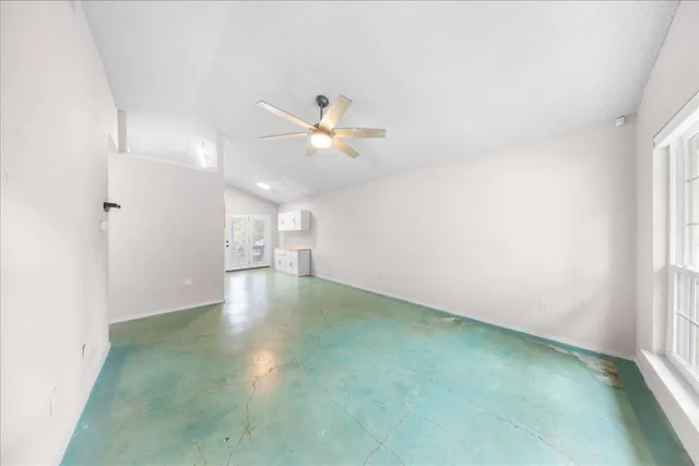 a view of a room with a ceiling fan and window