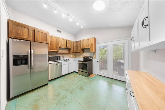 a kitchen with granite countertop a stove sink and cabinets