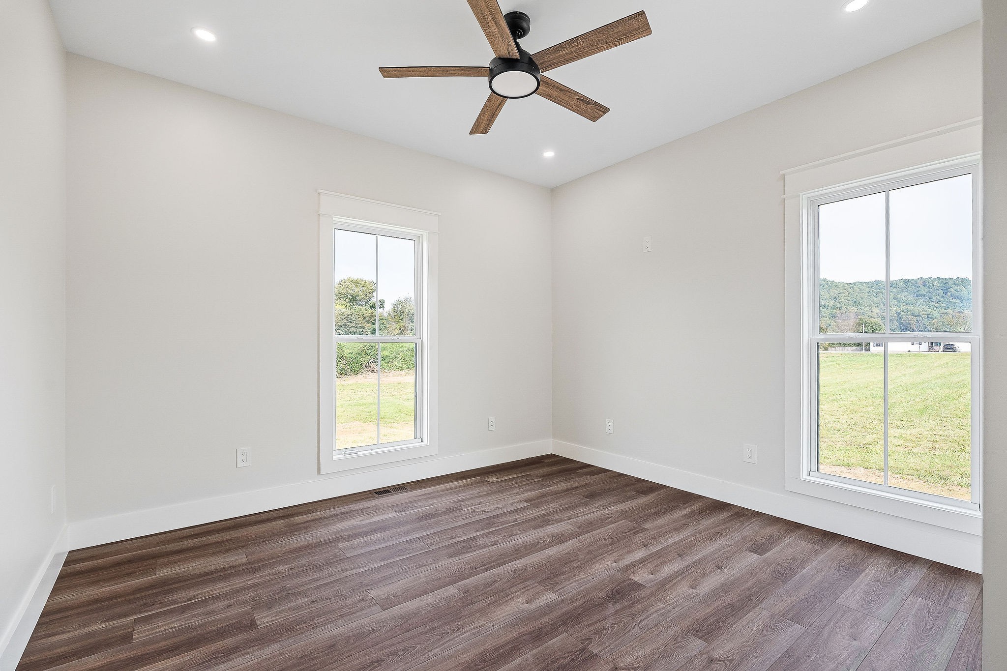 217 Oaklawn Cemetery Road Sparta, TN 38583 - Photo 23 of 42 an empty room with wooden floor ceiling fan and windows