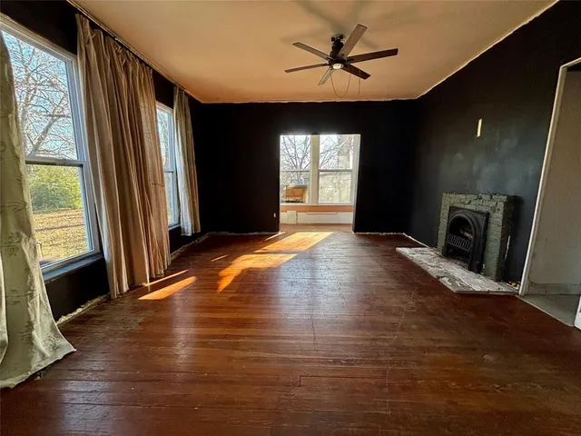 a view of an empty room with a window and fireplace