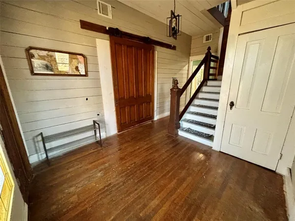 a view of a hallway with wooden floor and staircase