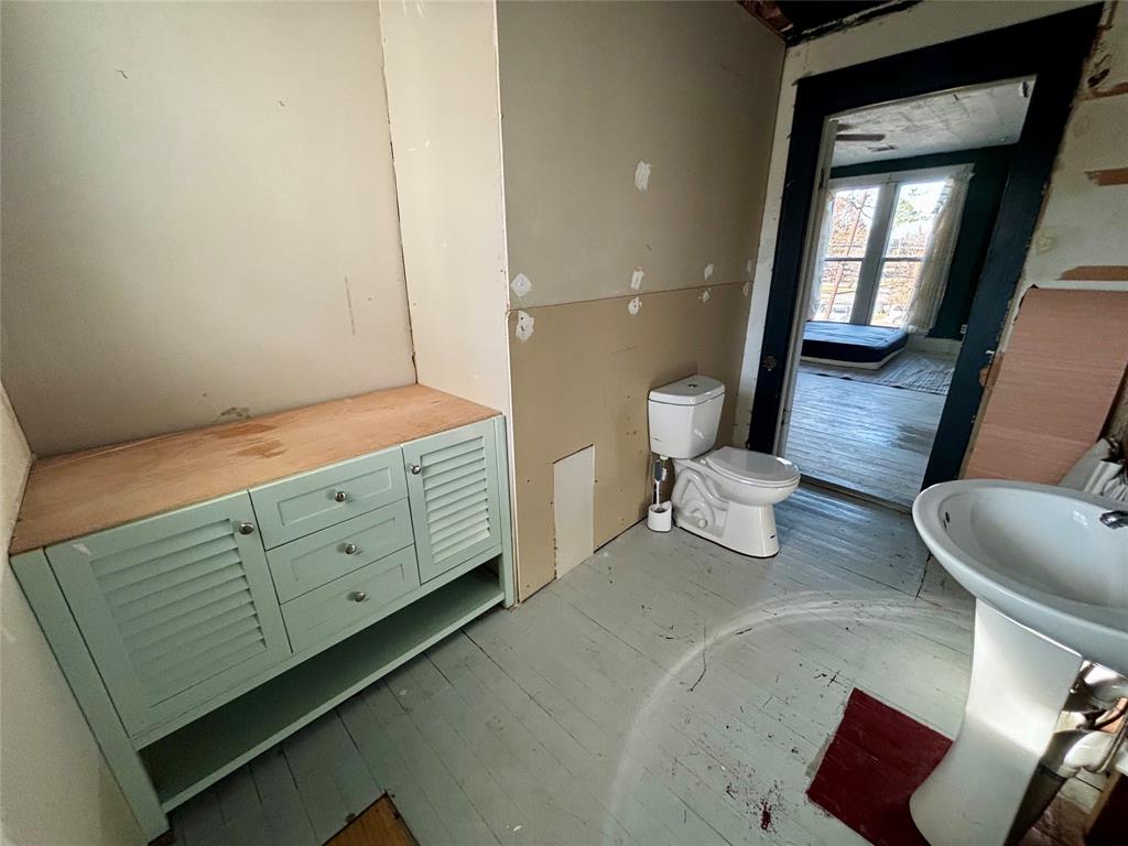 725 West 10th Street Bonham, TX 75418 - Photo 22 of 23 a bathroom with a double vanity sink mirror and toilet