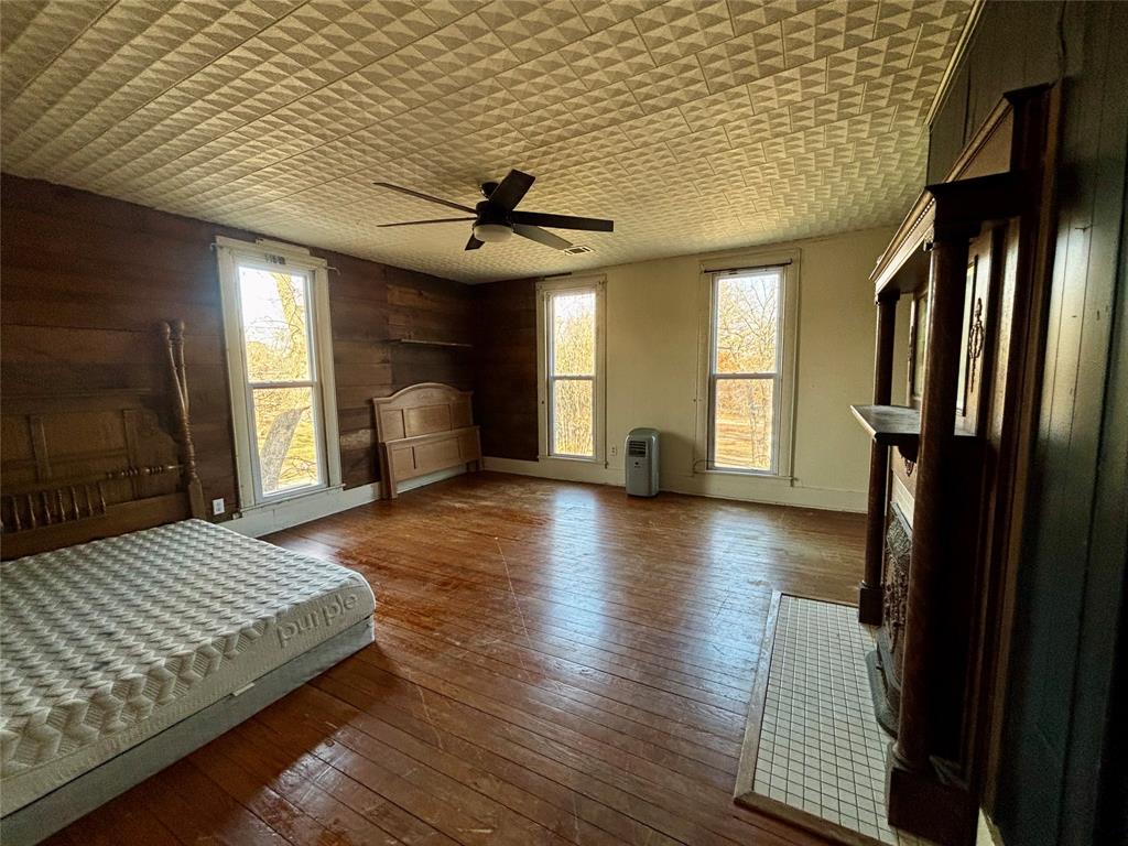 725 West 10th Street Bonham, TX 75418 - Photo 23 of 23 a bedroom with a bed and a chandelier