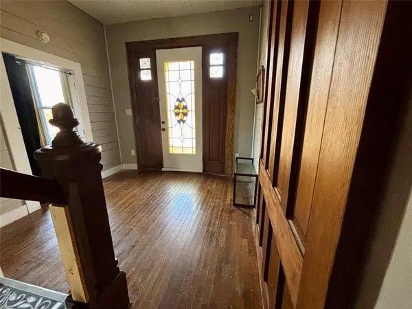 a view of a hallway with wooden floor and stairs