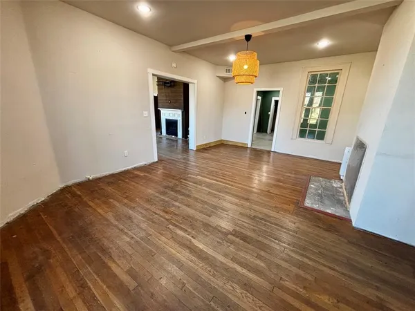 a view of a livingroom with wooden floor and stairs