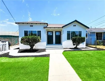 a view of a house with a yard and potted plants