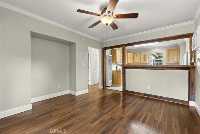 a view of a livingroom with wooden floor and a ceiling fan