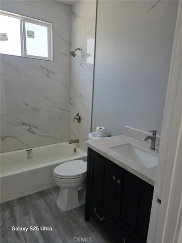 a bathroom with a granite countertop toilet a sink and a bathtub