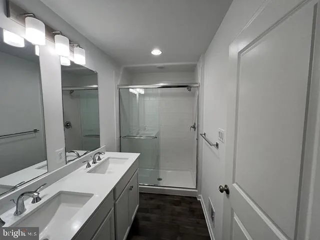 a bathroom with a double vanity sink mirror and shower