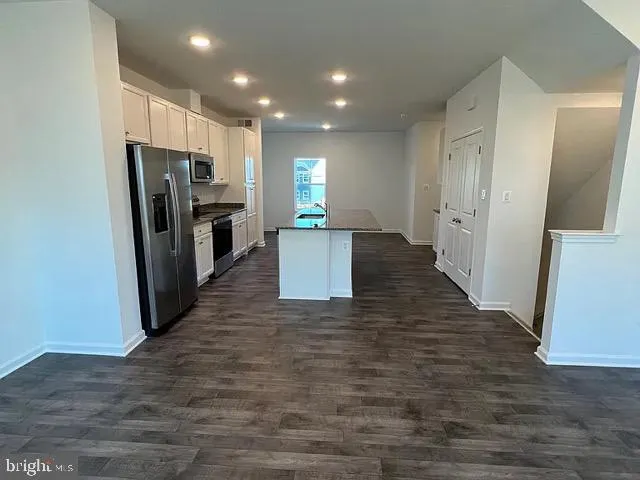 a view of a refrigerator in kitchen and a window