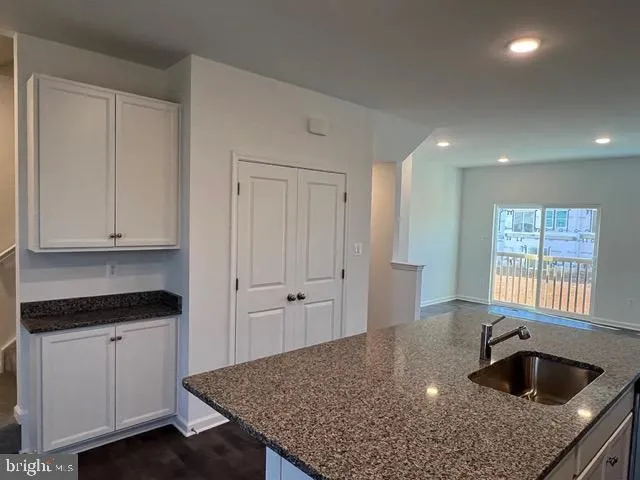 a kitchen with granite countertop a sink white cabinets and a granite counter tops