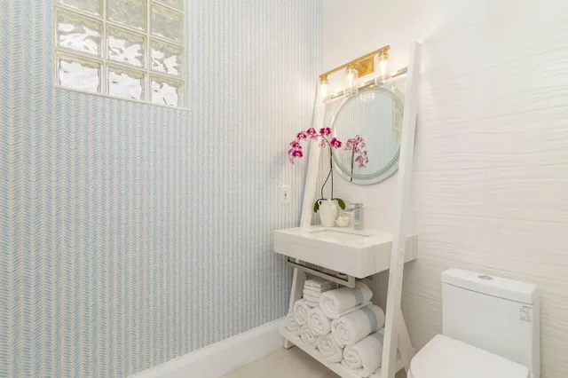 a bathroom with a sink a toilet and mirror