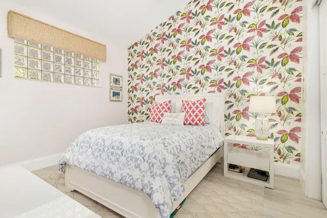 a bedroom with a bed a tv and wooden floor