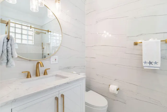 a bathroom with a sink toilet vanity and shower