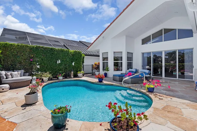 a view of a patio with table and chairs potted plants and a large tree