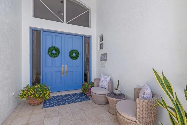 a living room with furniture a chandelier fan and a large window