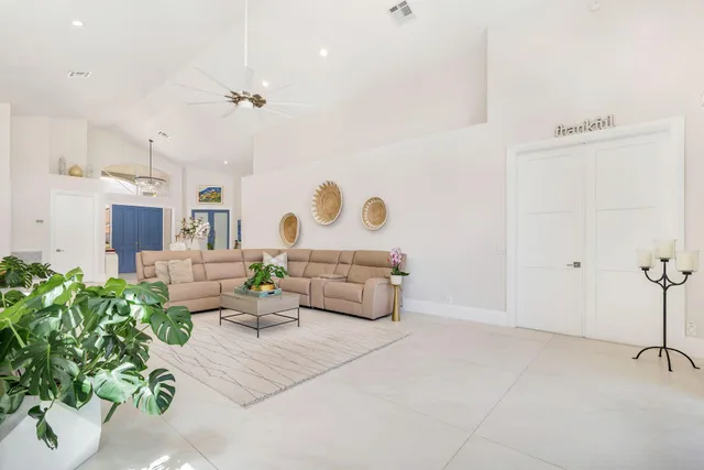a large white kitchen with granite countertop a sink white cabinets and stainless steel appliances