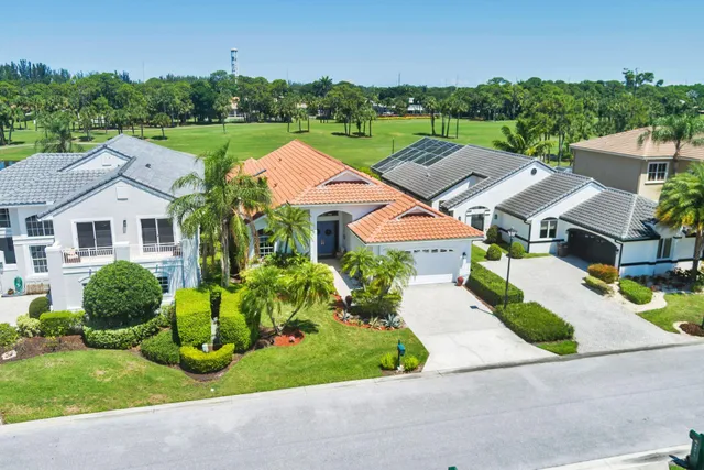an aerial view of residential houses with outdoor space and parking